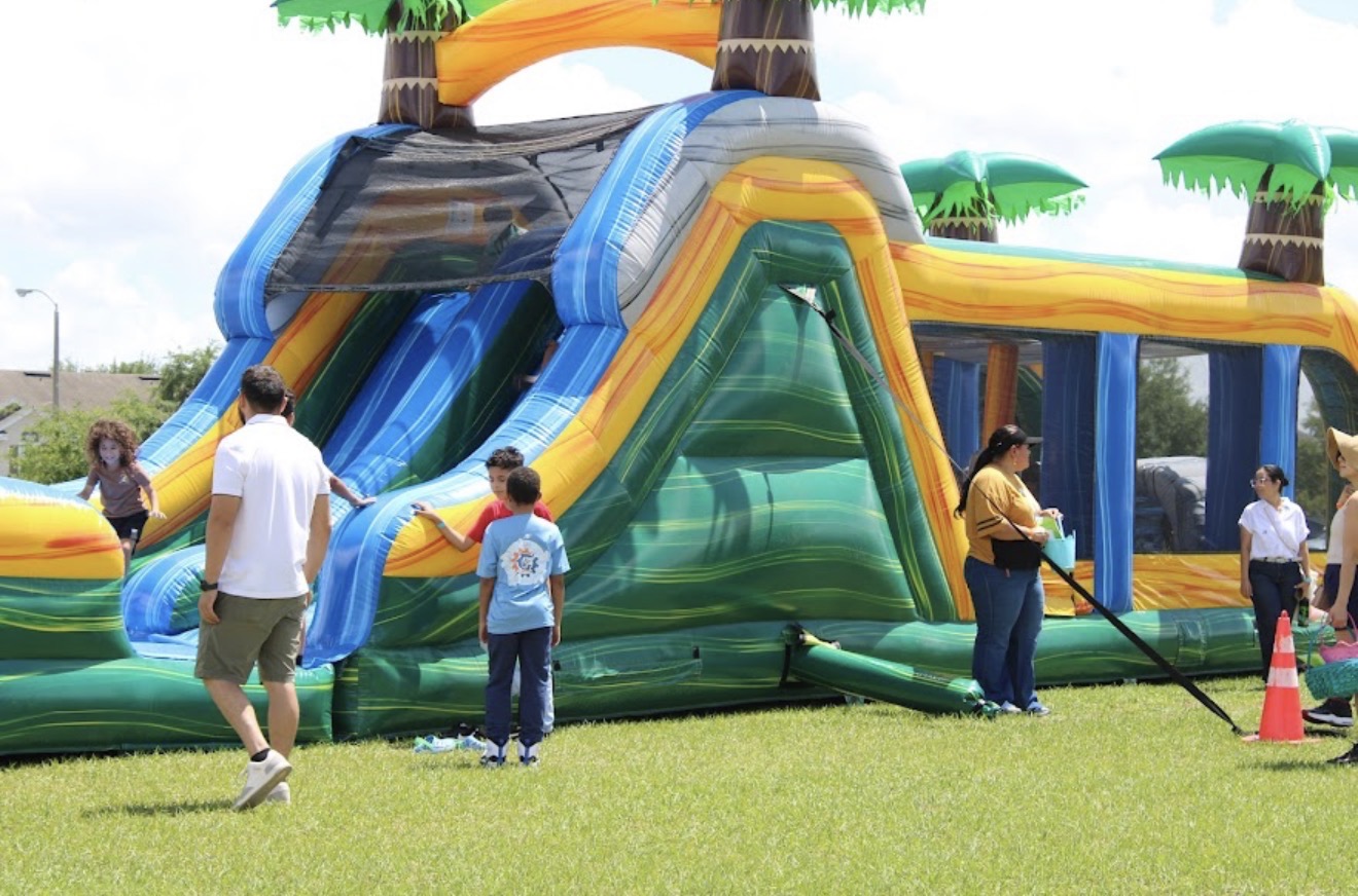 Real party rental setup , tropical bounce house combo with slide ready for a community event