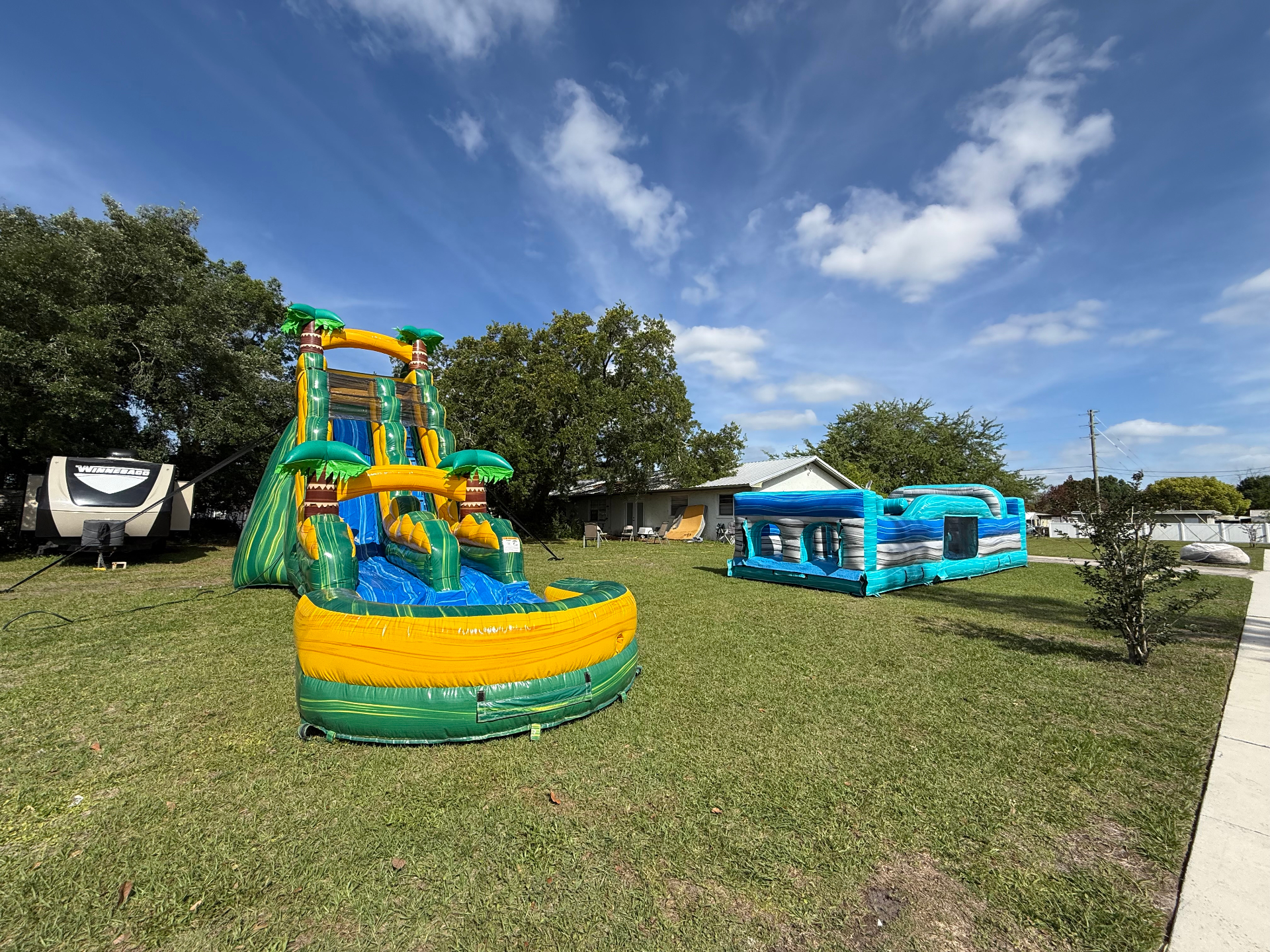 Tropical water slide and obstacle course set up in a yard