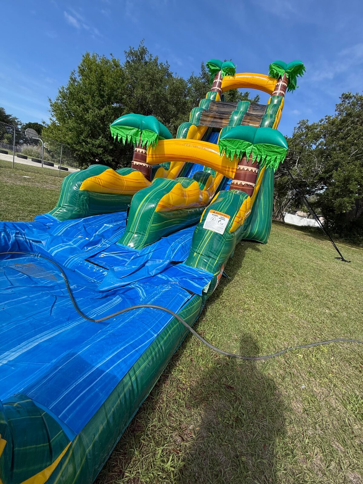 Low angle / hero of an inflatable water slide setup at a school event.